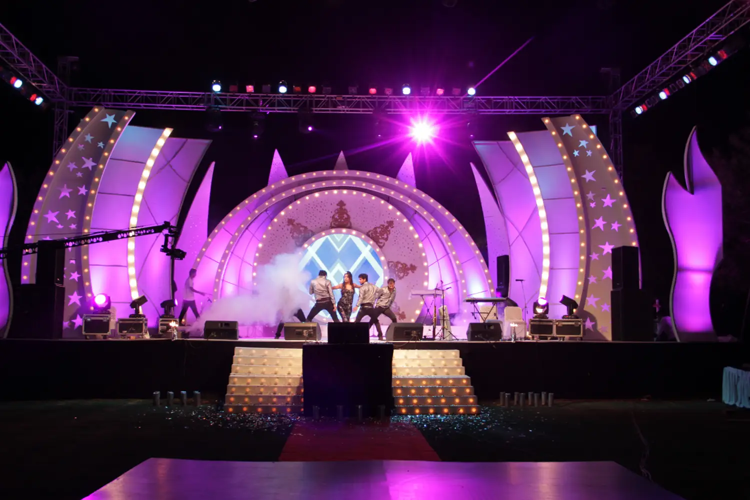 Men lighting ceremonial lamp at event with ITT banner in background